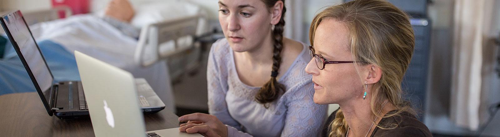 Student and professor observing computer screen